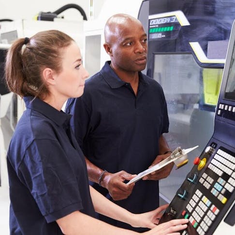 CNC machinists working on program. Image Credit: Shutterstock.com/Monkey Business Images