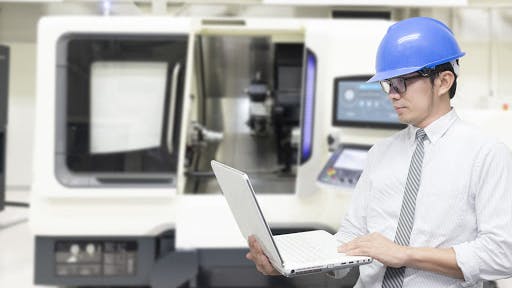 An engineer in front of a fabrication machine