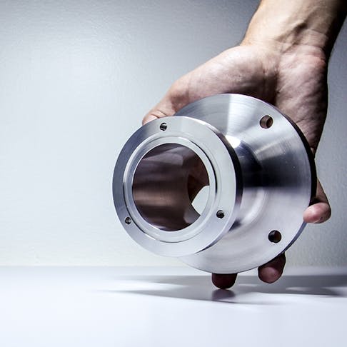 CNC machined part held by person