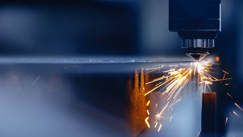 Laser CNC machine cutting into a metal surface.