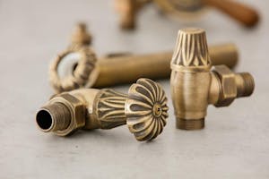Bronze water pipe fittings with floral designs. Image Credit: Shutterstock.com/Artak Margaryan