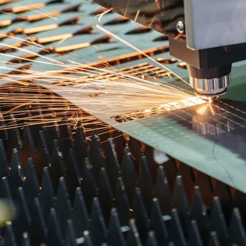 A fiber laser is used to cut into a metal plate.