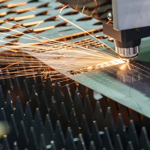 A fiber laser is used to cut into a metal plate.