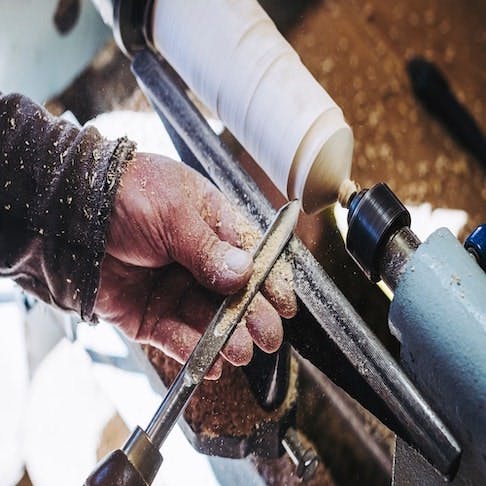 Wood turner making a spinning top - Image Credit: Shutterstock/PicksArt