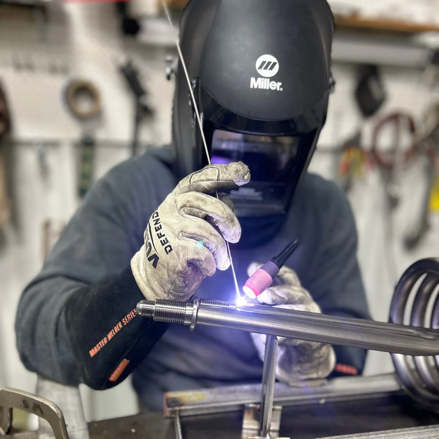 An engineer at Aqua Logic TIG welding titanium fitting to a titanium coil.