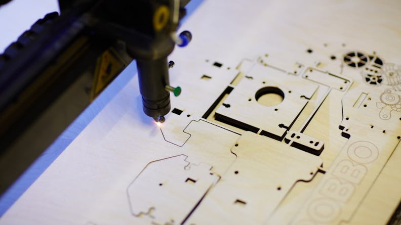 A laser engraving machine cutting details into wood.