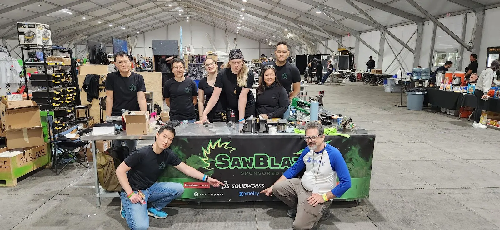 The Battlebots pit with team SawBlaze and Xometry's Simon Arthur delivering parts.