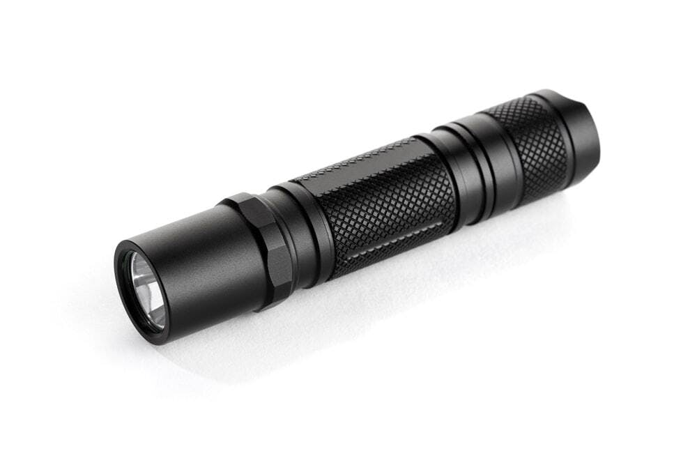 black anodized flashlight on white background