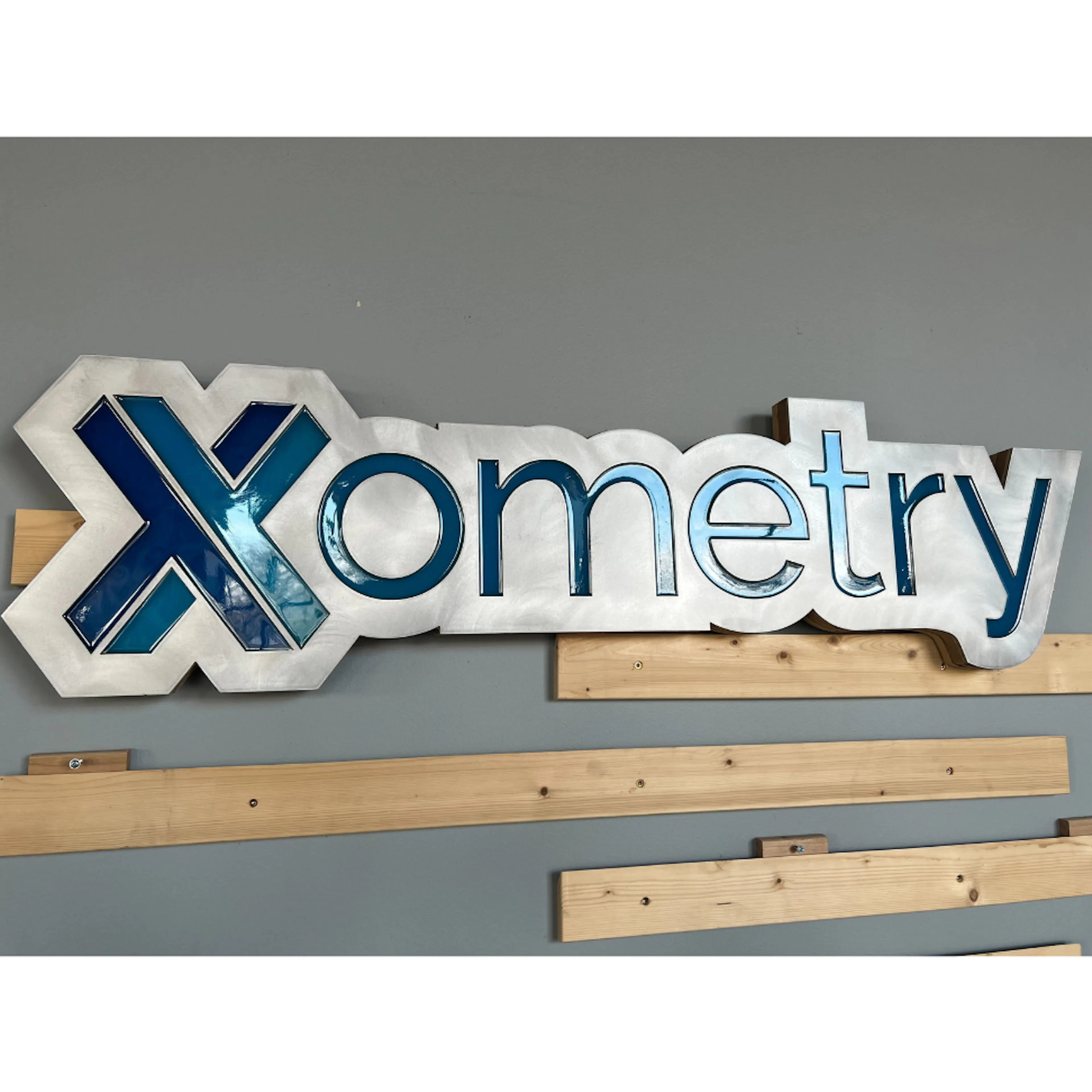 A waterjet cut aluminum "Xometry" sign