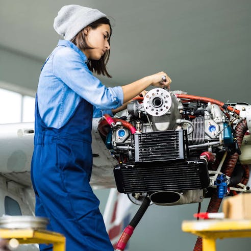 Woman repairing airplane turboprop engine