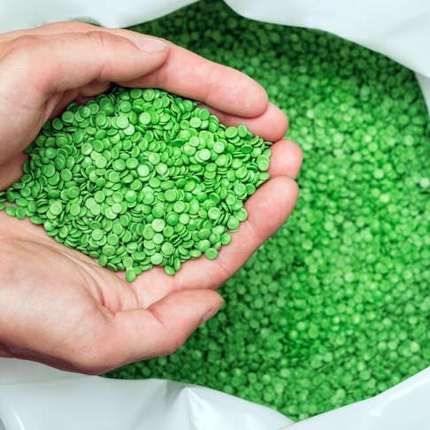 Green biodegradable plastic pellets. Image Credit: Arsenii Palivoda/Shutterstock.com