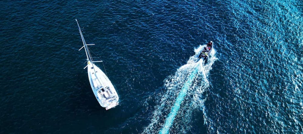 A sailboat and a fast boat on the ocean