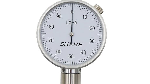 A spring loaded device designed to measure durometer hardness
