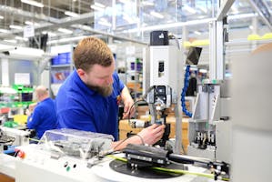 Operator assembling machine in factory. Image Credit: Shutterstock.com/industryviews