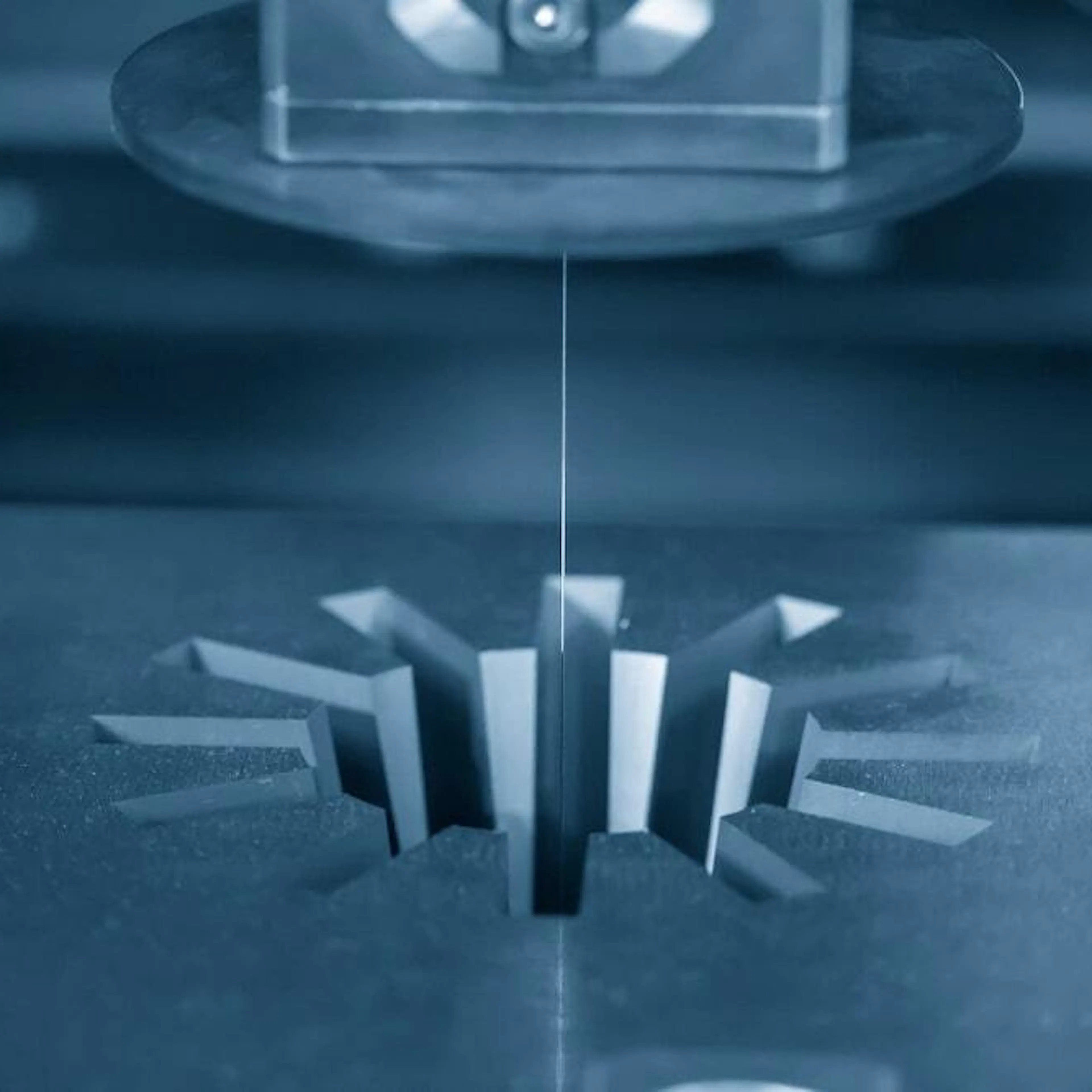 A wire EDM machine cutting a gear shape. Image Credit: Shutterstock.com/Pixel B