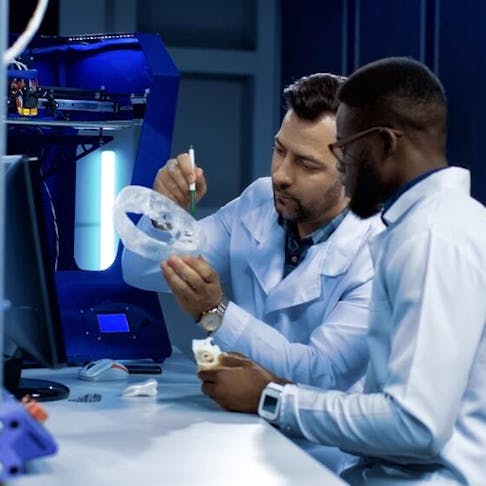 Researchers discussing 3D printed prosthetics. Image Credit: Shutterstock.com/Frame Stock Footage