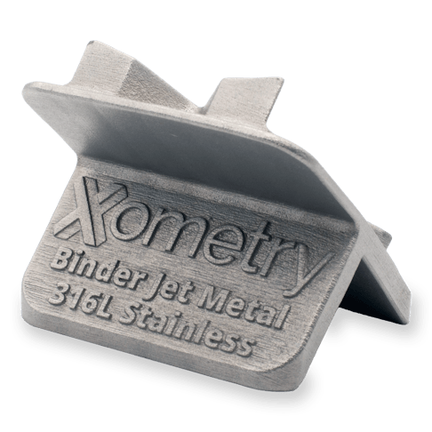 The back of a 316L stainless steel binder jet printed Xometry tile showcasing text.
