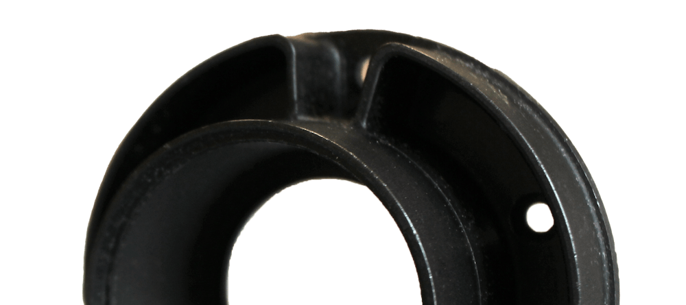 Cylindrical CNC-machined part made of black plastic.