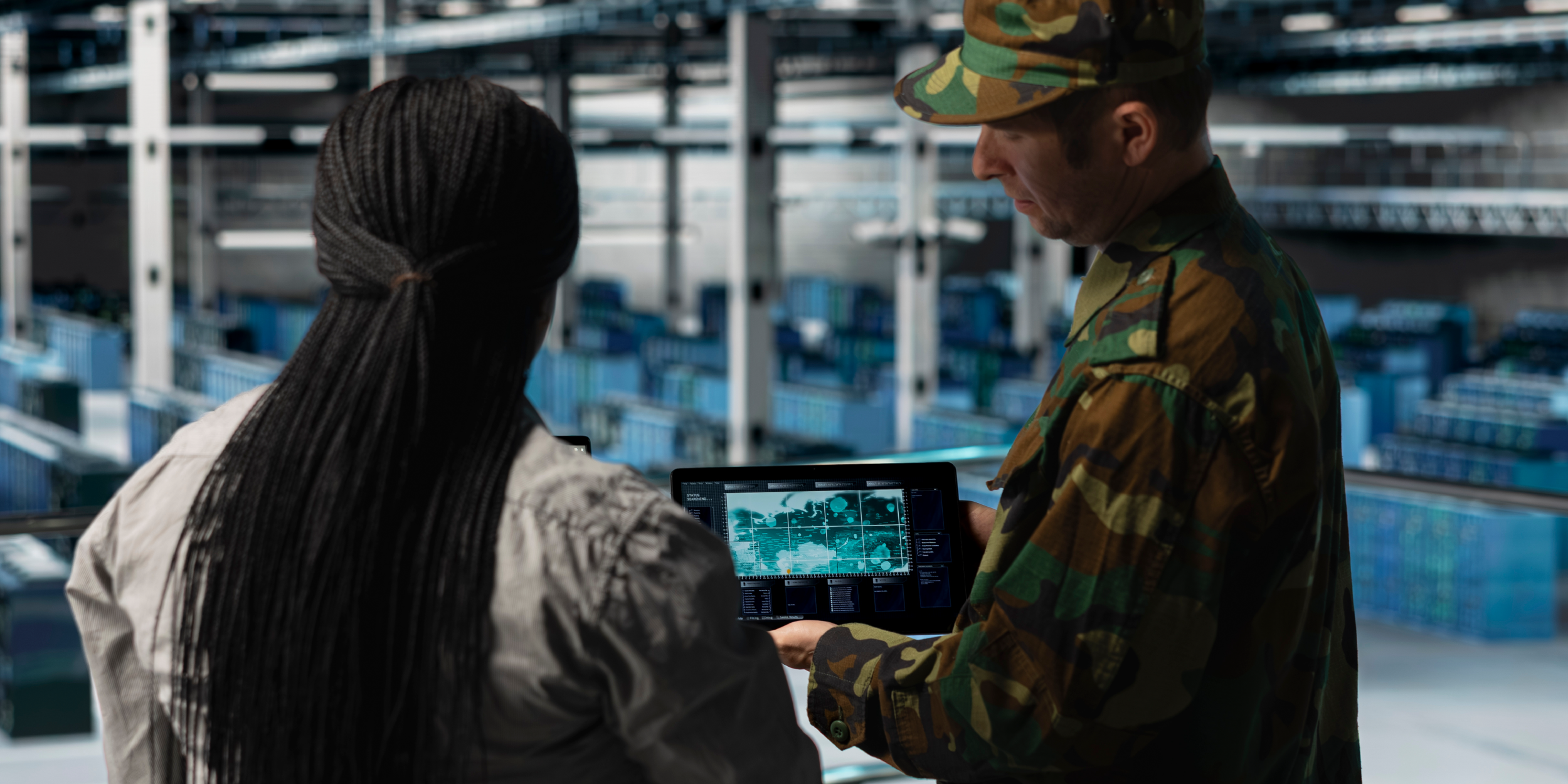 Army personnel watching a test flight on a screen