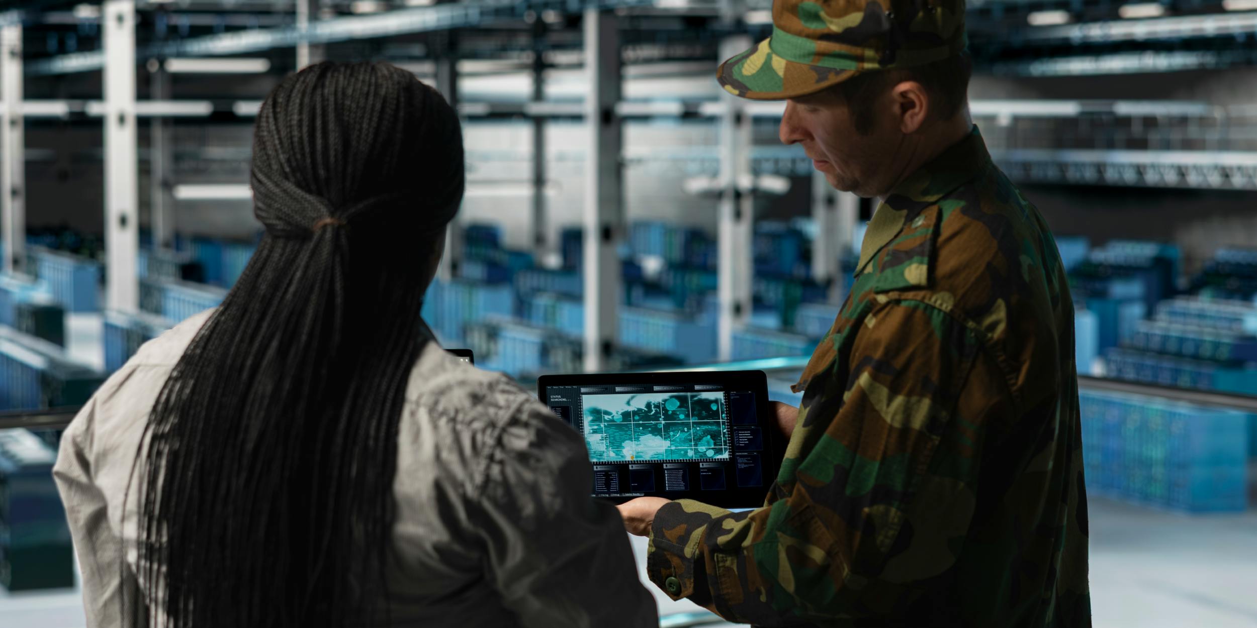 Army personnel watching a test flight on a screen