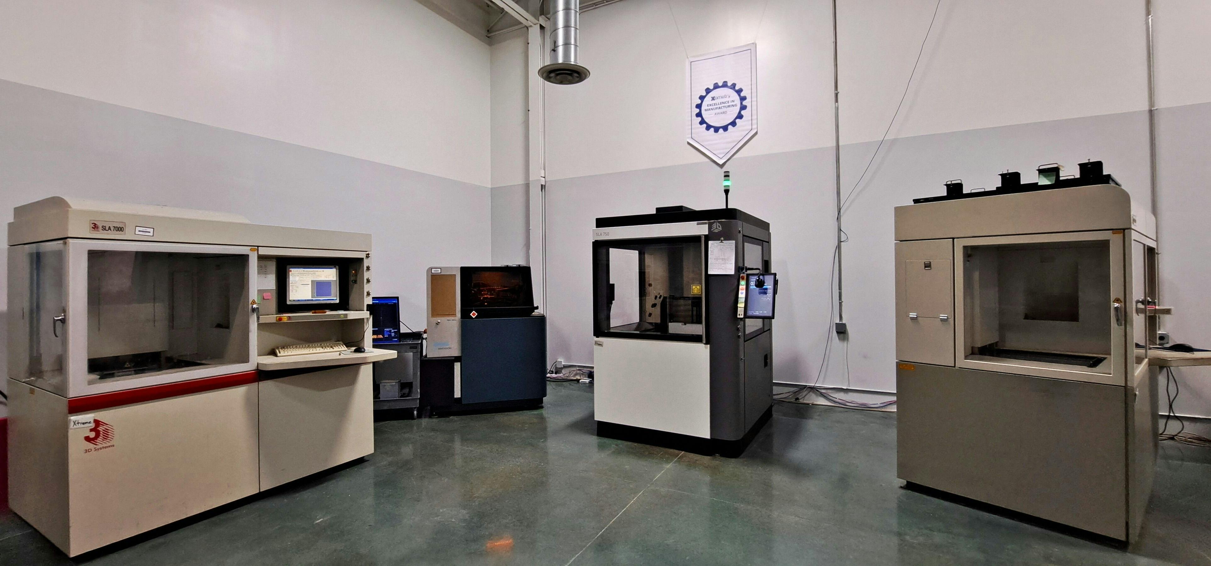 The Technology House facility with a Xometry Excellence in Manufacturing Award banner hanging on the wall