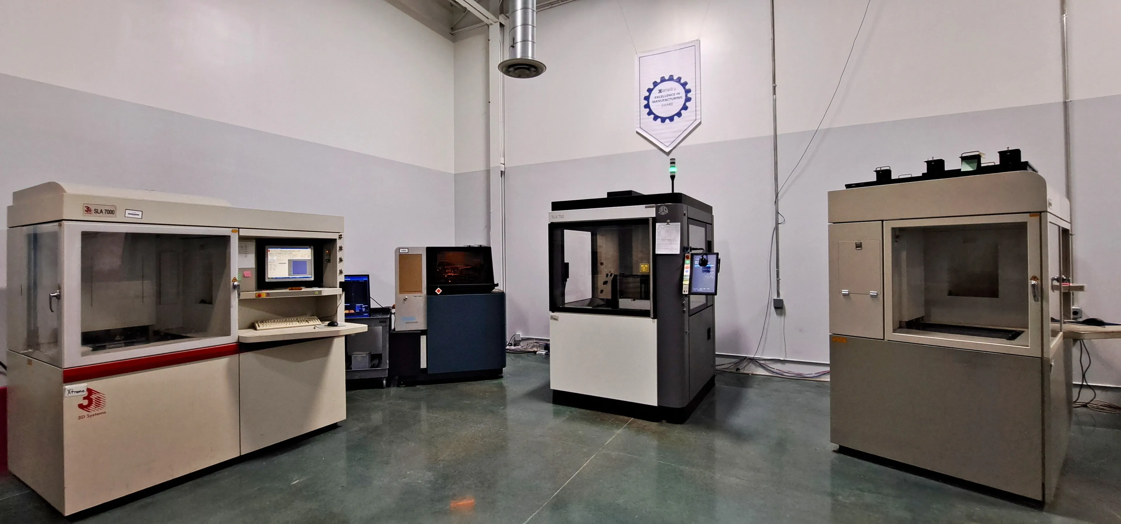 The Technology House facility with a Xometry Excellence in Manufacturing Award banner hanging on the wall