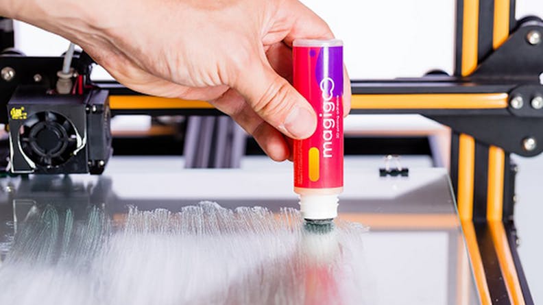 A stick adhesive being applied to the bed of a 3D printer.