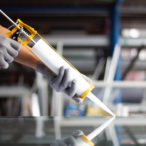 Applying silicone adhesive. Image Credit: Shutterstock.com/noprati somchit