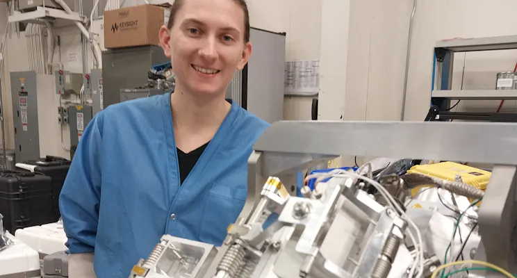 UNH physics graduate student Diana Swanson poses with the ion gauge mounted on the RENU3 rocket.