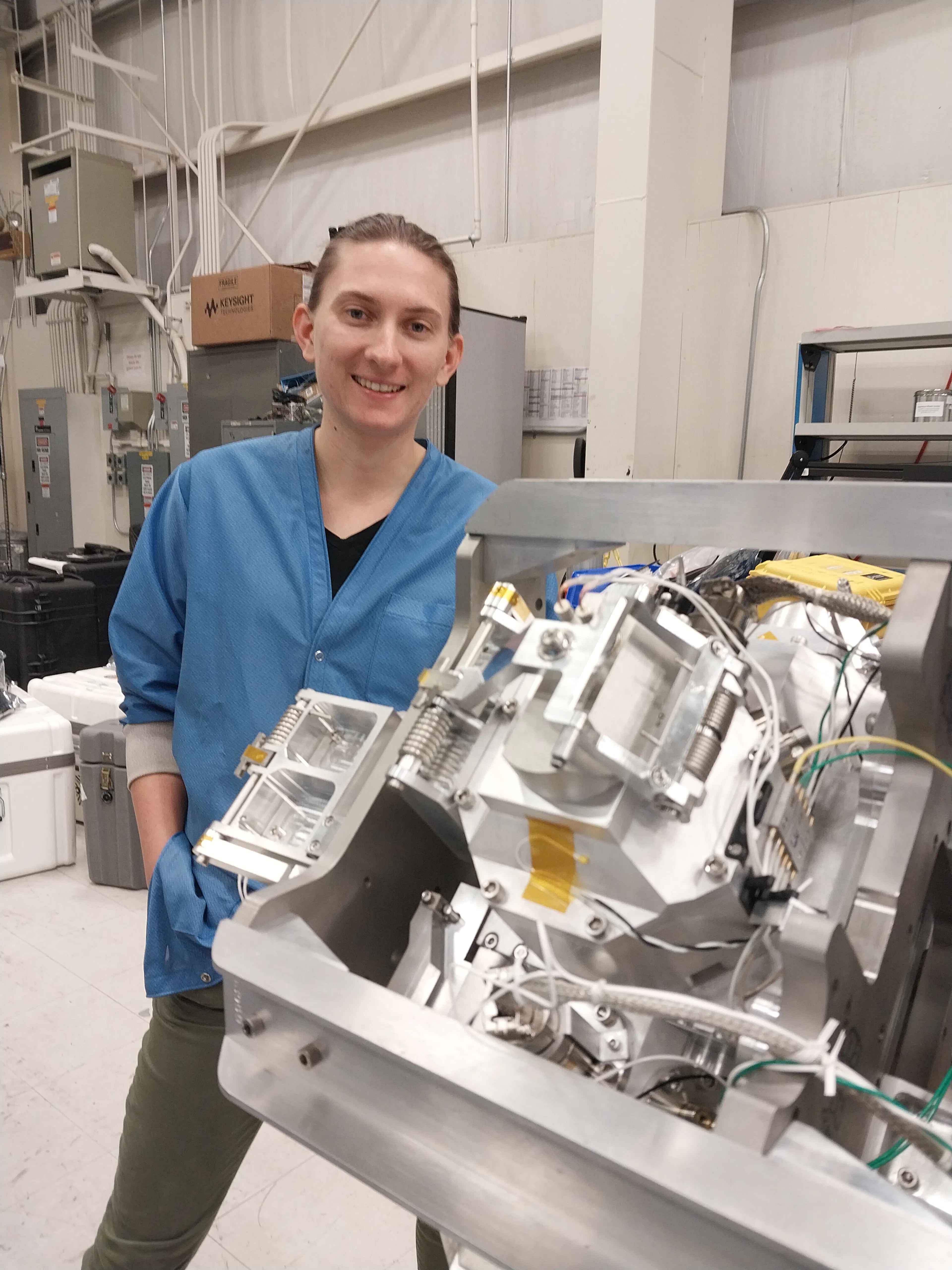 UNH physics graduate student Diana Swanson poses with the ion gauge mounted on the RENU3 rocket.