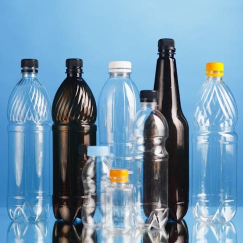 Plastic bottles on solid blue background. Image Credit: nikkytok/Shutterstock.com