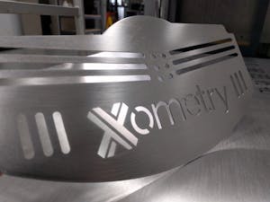 Sheet metal laser cut and punched plate with Xometry logo