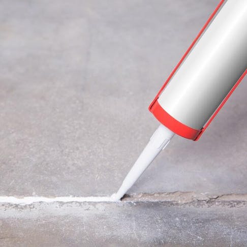 Filling in a crack with silicone sealant. Image Credit: Shutterstock.com/Dimik_777
