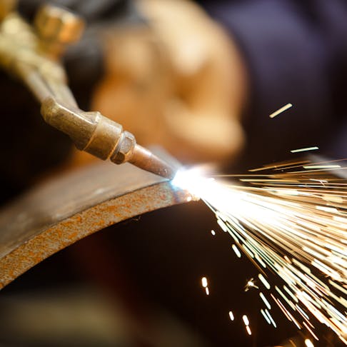 Worker using Oxyacetylene gas to weld in sheet metal factory