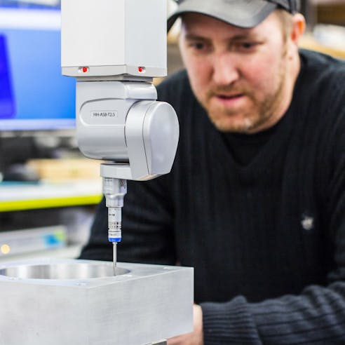 Xometry technician operating a CMM machine