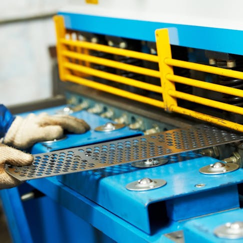 Worker operating guillotine shears machine. Image Credit: Shutterstock.com/Dmitry Kalinovsky