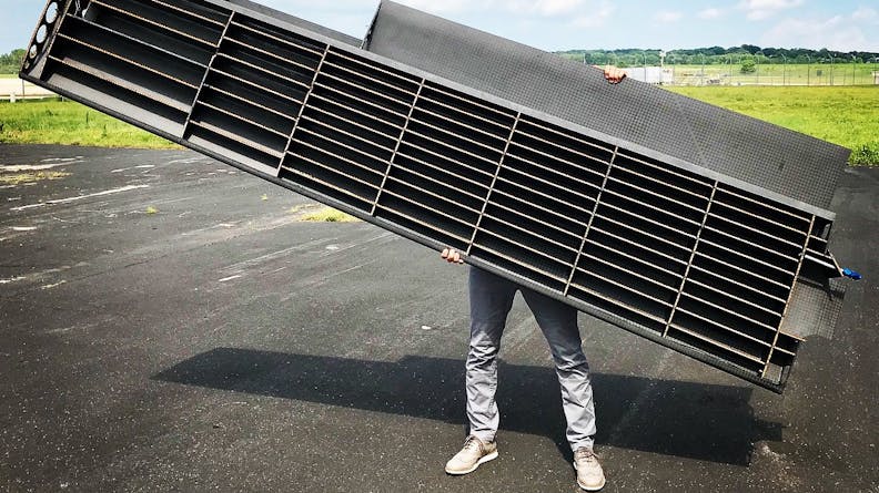 a photo of Ryley Karl holding up one half of the wing with the internal side showing. 