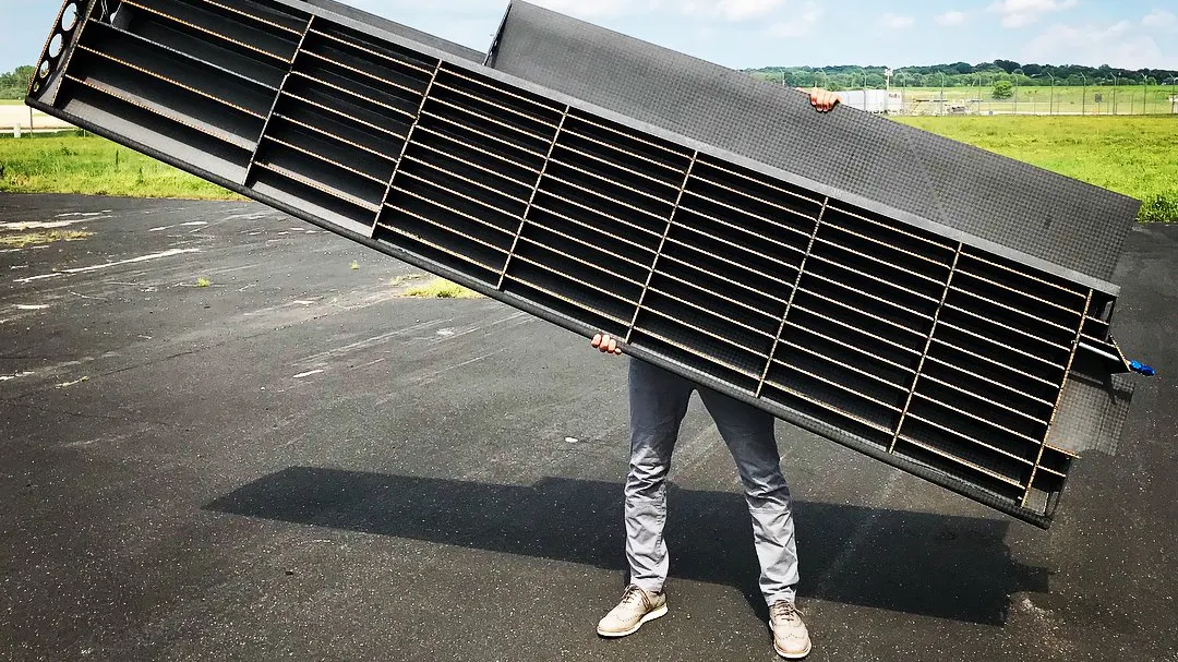 a photo of Ryley Karl holding up one half of the wing with the internal side showing.