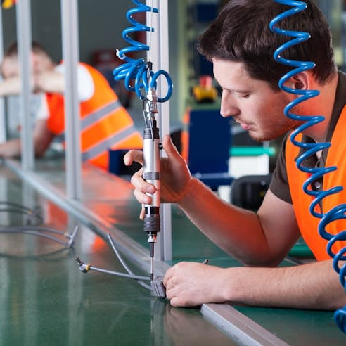 A worker performing assembly in a factory. Image Credit: ESB Professional/Shutterstock.com