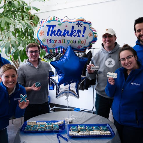 Xometry associates in Lexington at an employee appreciation event with Xometry-branded cookies and balloons