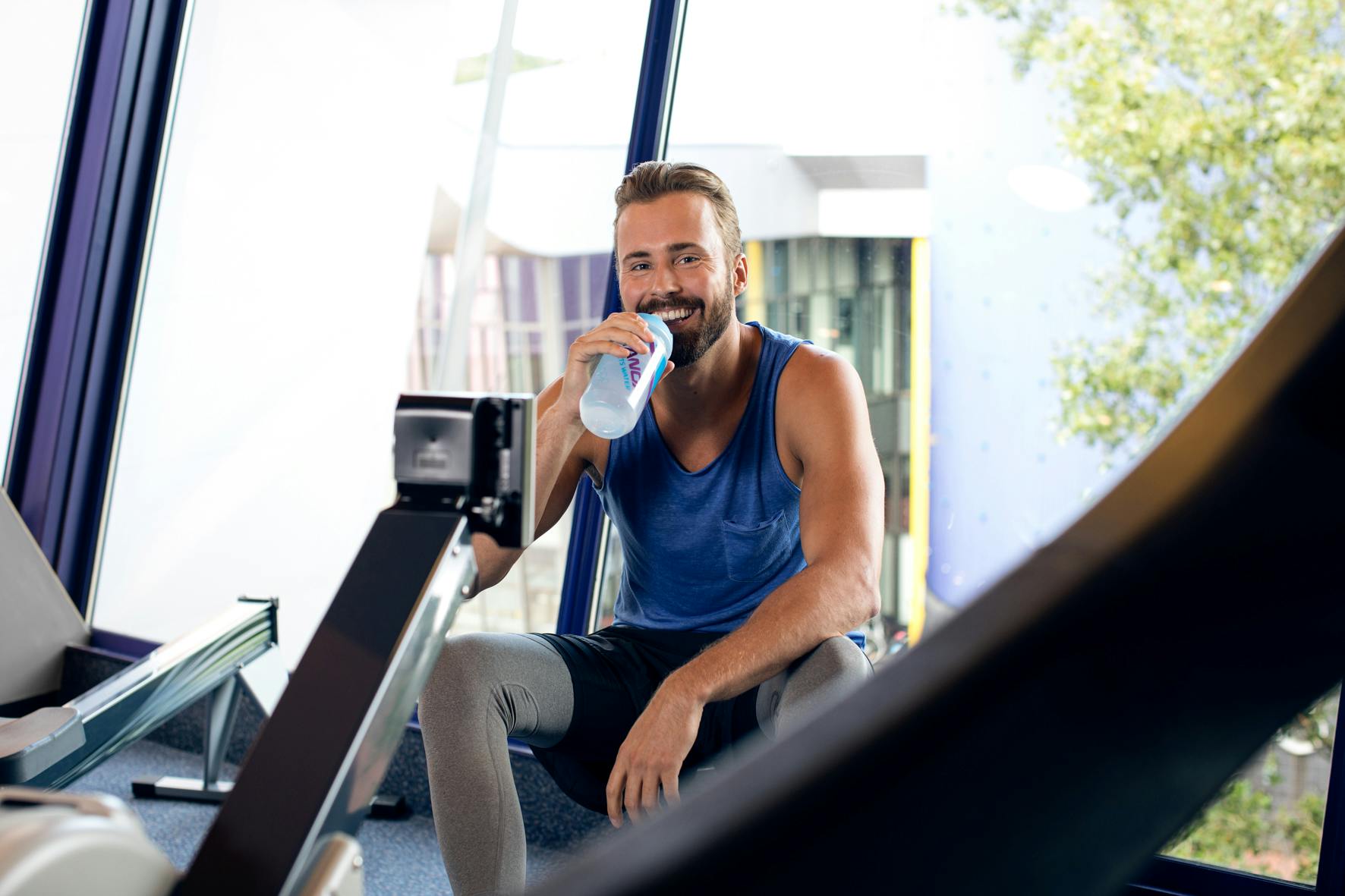Ein Mann trinkt Wasser in einem Fitnessstudio
