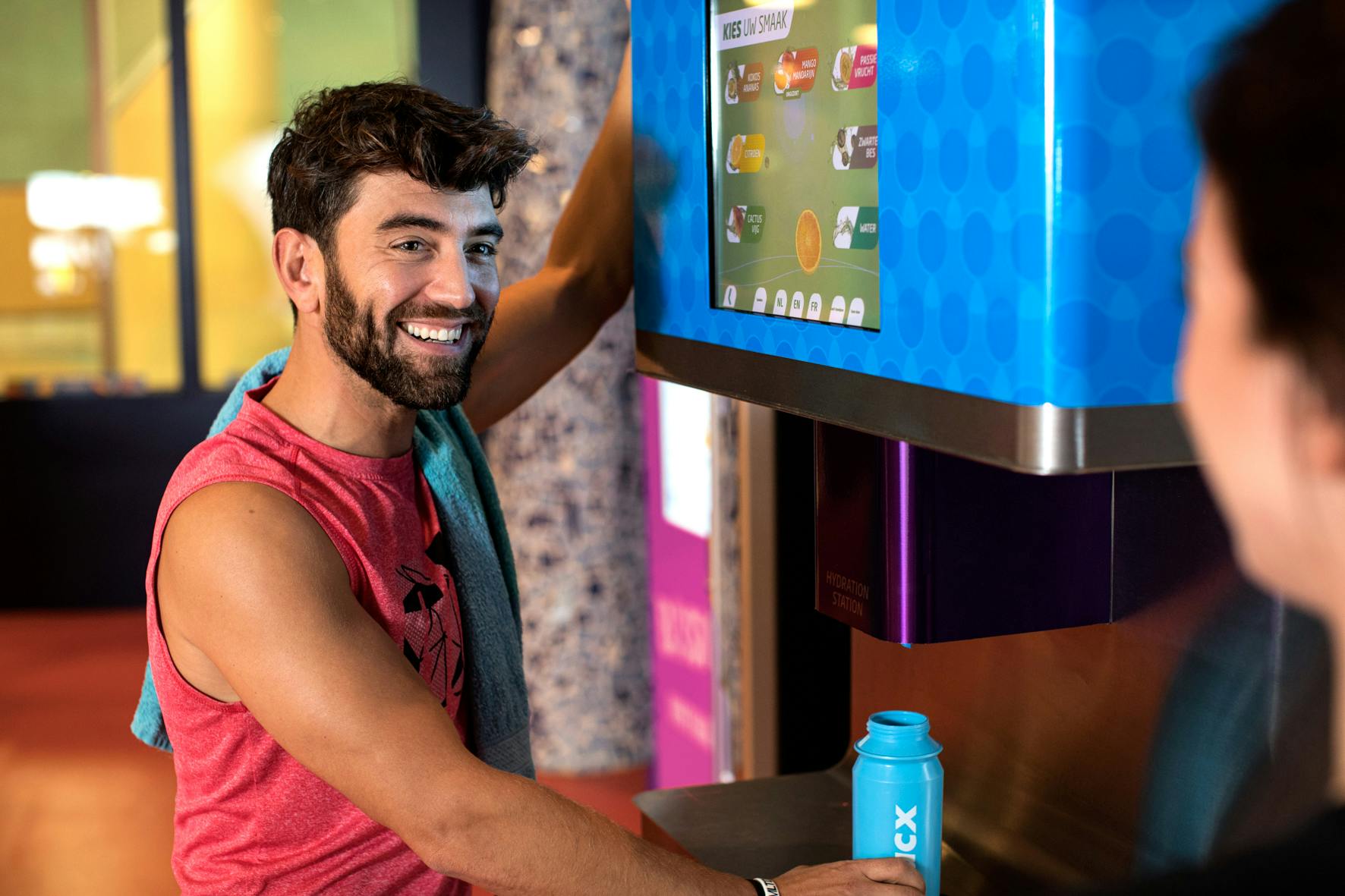 A man talking with another person in front of the Hydration Station