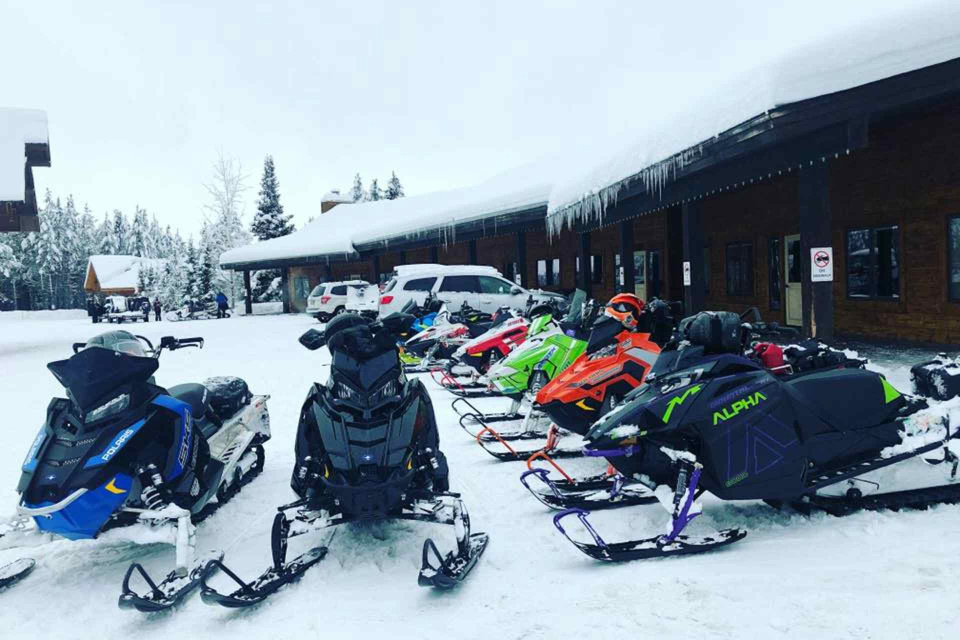 Snowmobiles belonging to guests residing at the Pond's Lodge in the Yellowstone Teton Territory