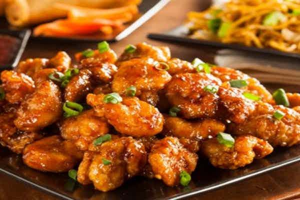 A heaping plate of sweet and sour chicken topped with green onions, offered at the Chinese Garden Restaurant of the Yellowstone Teton Territory, located in Idaho Falls.