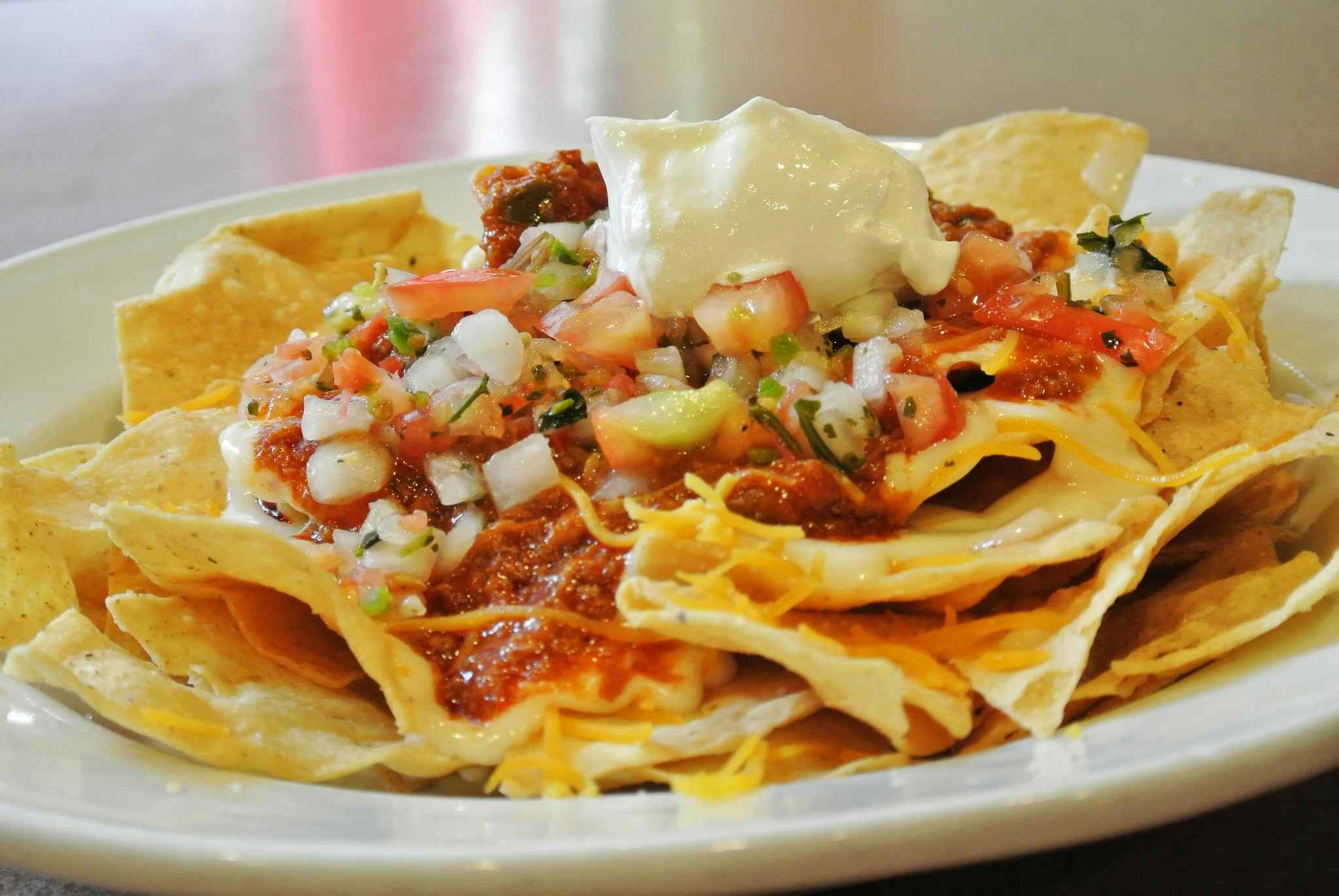Plate of nachos with housemade pico de Gallo, cheese, and sour cream, offered at Denny's of Idaho Falls.