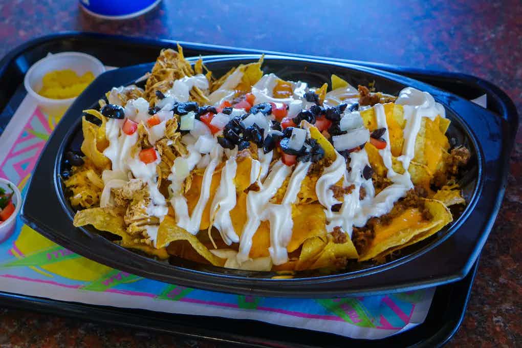Cheesy nachos covered in olives, tomatoes, sour cream, and beef, courtesy of Fiesta Ole of Eastern Idaho.