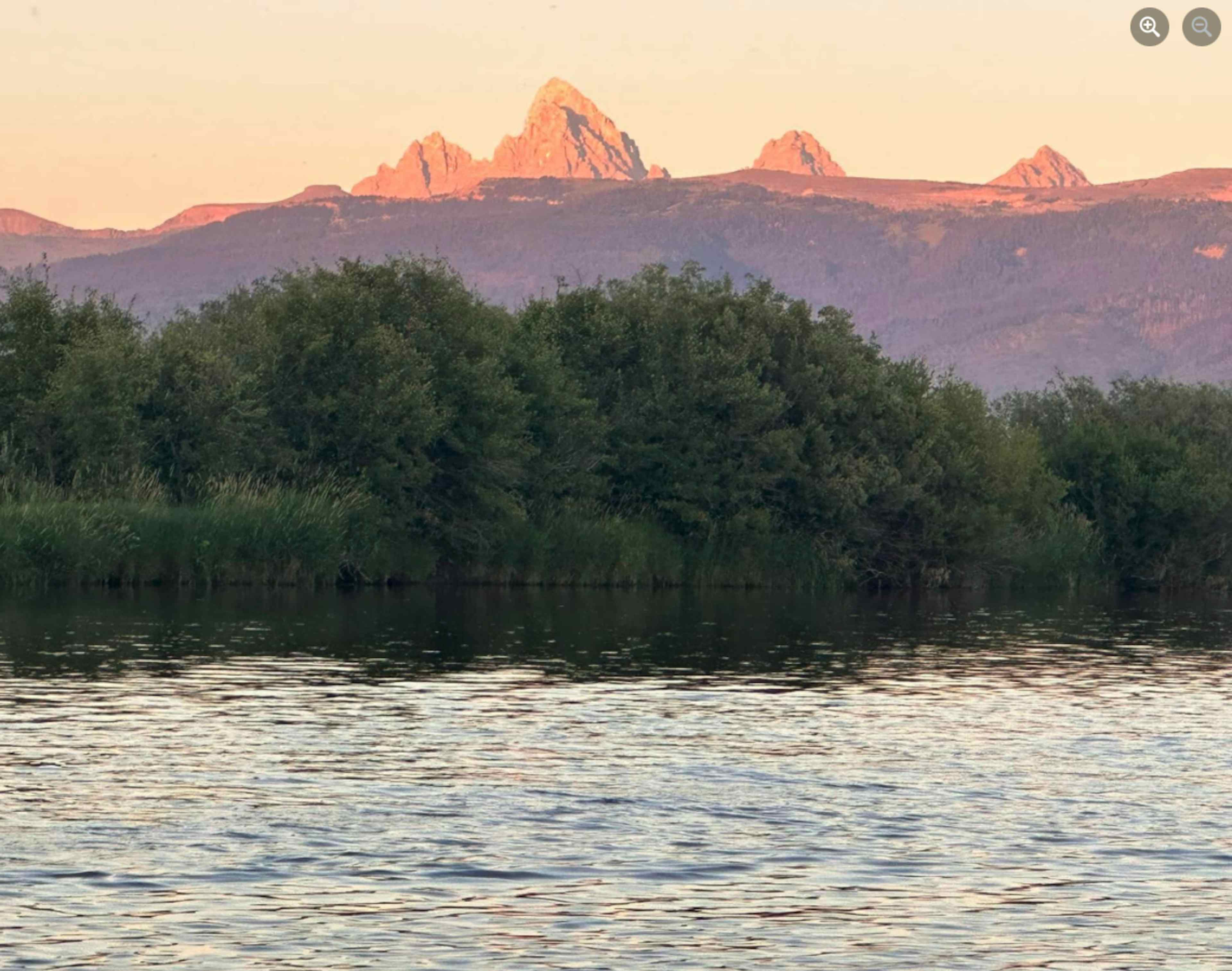 Picture of alpenglow on the Grand Teton and Teton Mountain Range from the Teton River in Teton Valley, a part of Eastern Idaho and Yellowstone Teton Territory.