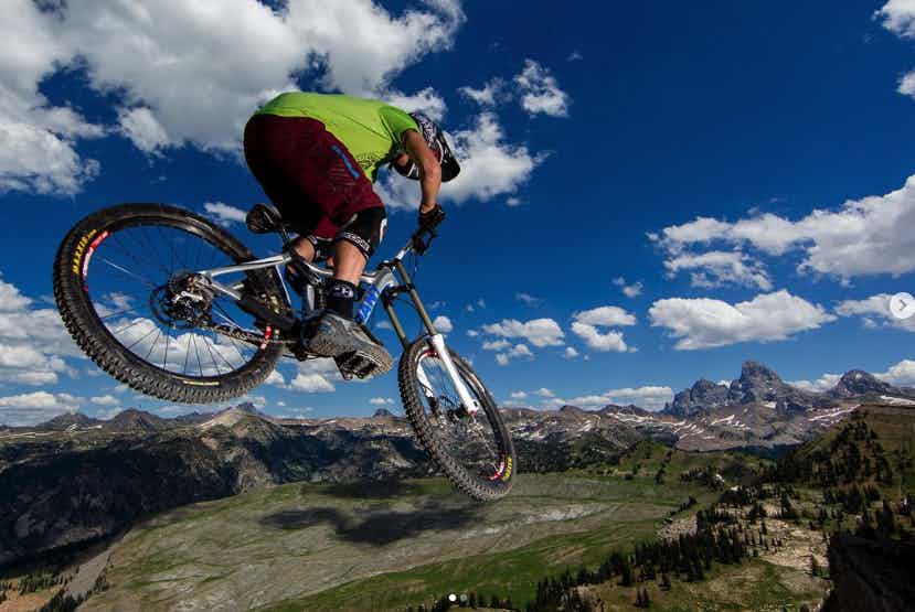 Mountain Biker at Grand Targhee Resort in front of the Teton Mountains in Eastern Idaho, a part of Yellowstone Teton Territory.