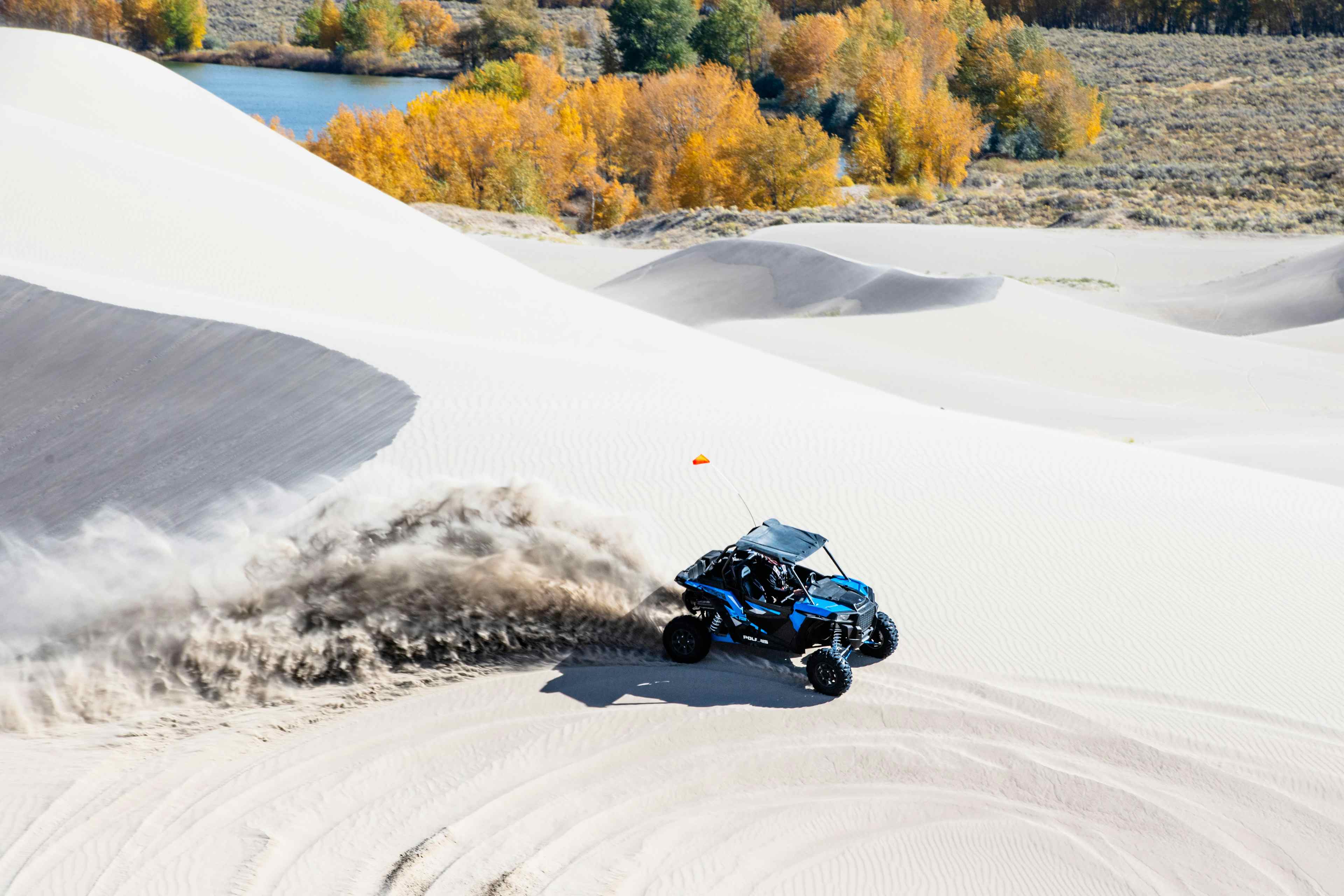 An atv races over sand dunes in St. Anthony is Eastern Idaho, a part of Yellowstone Teton Territory.
