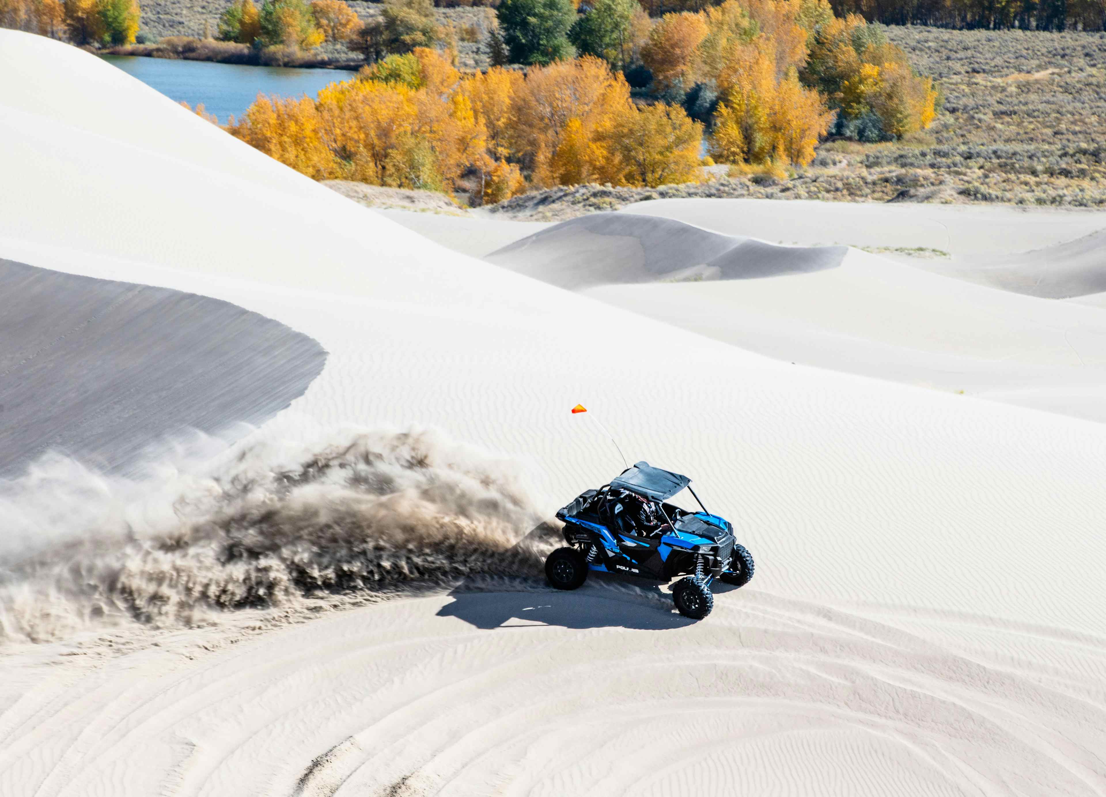 An atv races over sand dunes in St. Anthony is Eastern Idaho, a part of Yellowstone Teton Territory.